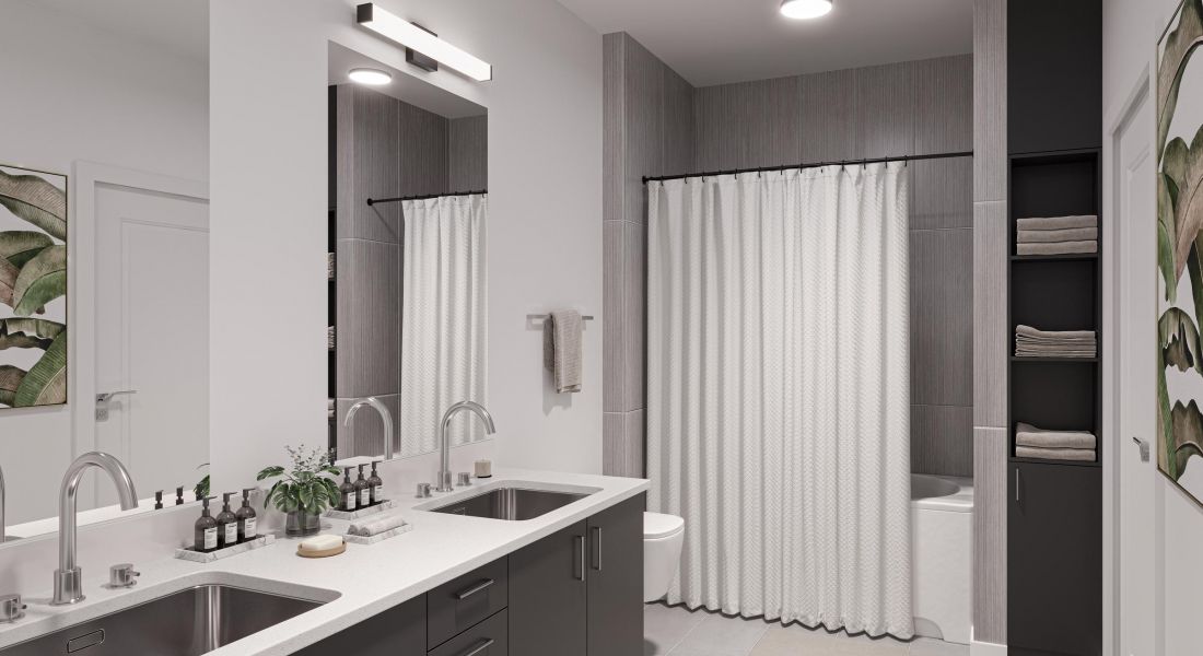 The Wade is A modern bathroom featuring a spacious shower and a sleek sink, showcasing contemporary design elements.