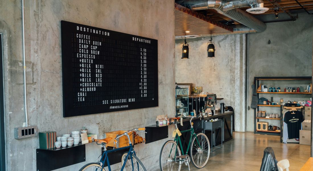 The Wade A cozy coffee shop featuring bicycles parked outside and a chalkboard displaying the daily specials.