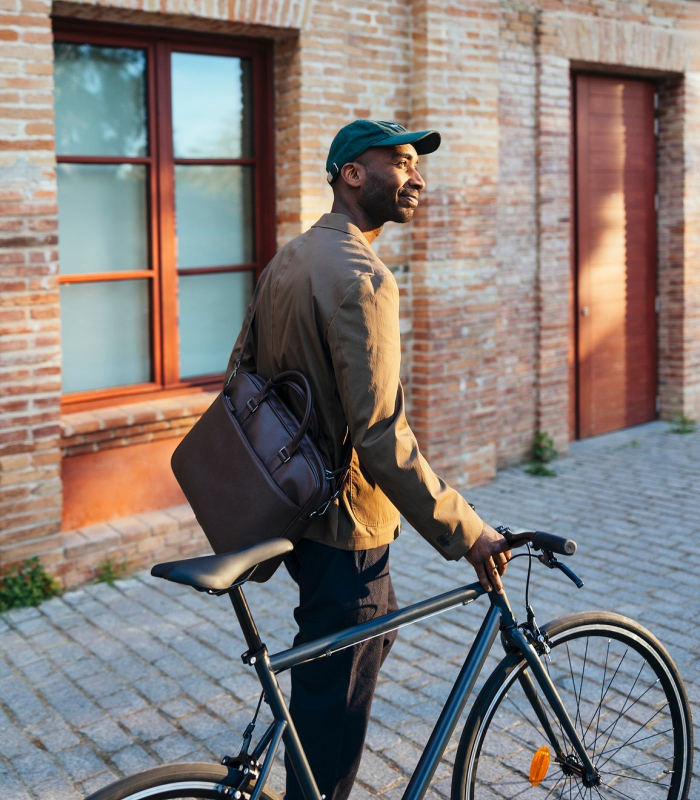 The Wade A man wearing a backpack stands next to a bicycle, ready for an outdoor adventure.