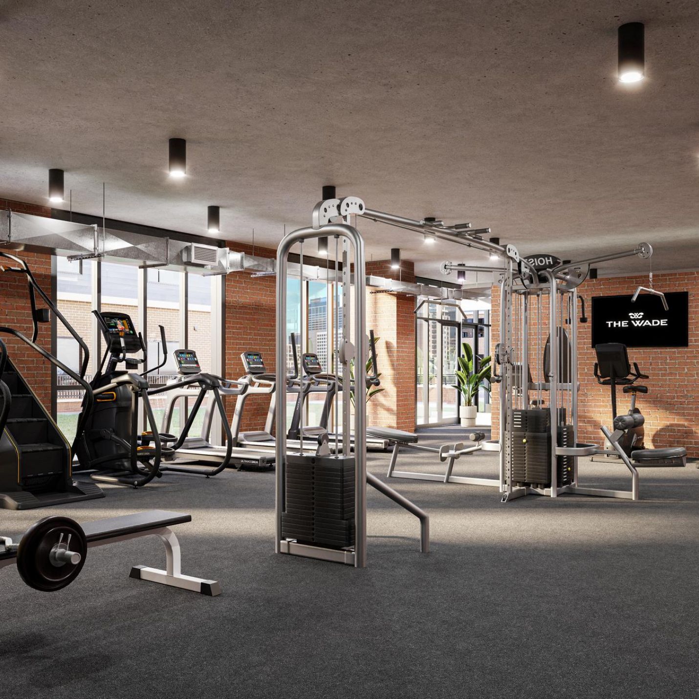 The Wade A gym room featuring various exercise equipment and a large window allowing natural light to enter.