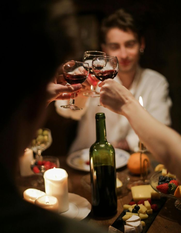 The Wade A group of diverse individuals joyfully toasting with wine glasses in a celebratory setting.